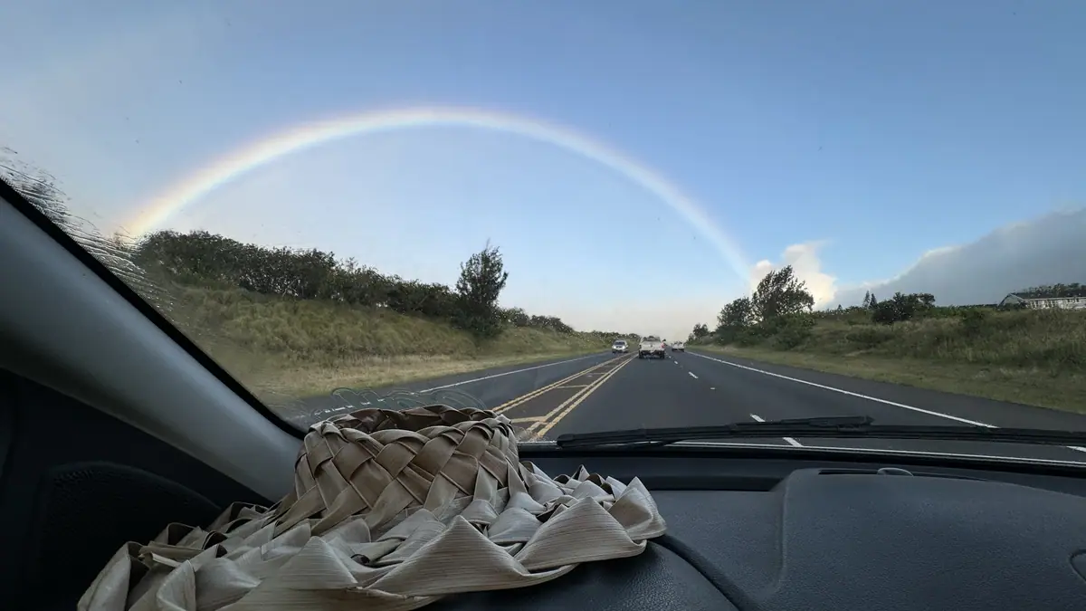 A rainbow over the Hana Highway seen through the windshield